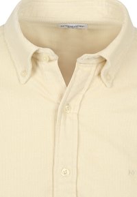 Cremfarbene Cordhemd mit Button-down-Kragen, Frontblende und zwei sichtbaren Knöpfen. Dezenter, gerippter Textur und gesticktem Logo.