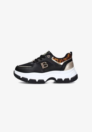 Sneaker nera con una spessa suola bianca, parte superiore in tessuto a rete e sintetico, accento leopardato, hardware dorato e dettaglio del logo sul lato.