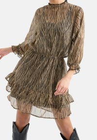 Durchsichtiges braunes Kleid mit schwarzen Zebra-Streifen, langen Puffärmeln, rüschiertem Saum und einem elastischen Bund für eine figurbetonte Silhouette.