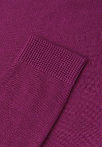 Tissu tricoté violet avec un détail de poignet côtelé. Texture lisse avec des coutures régulières sur toute la surface.