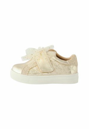 Sneaker metallic oro con tessuto testurizzato, dettagli in pizzo e un fiocco in tulle. Presenta una suola in gomma bianca e una chiusura con strap in velcro.