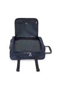 Borsone da viaggio blu navy con cerniera aperta, dotato di un ampio interno nero, maniglia e cinturini regolabili. Tasca con cerniera all'interno.