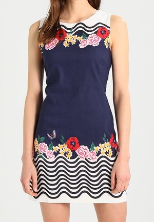 Ärmelloses Marineblaues Kleid mit weißen oberen und unteren Einsätzen, verziert mit bunter Blumenstickerei und schwarzen wellenförmigen Streifen am Saum.