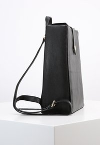 Svart läderaxelväska med en strukturerad, rektangulär form, slät yta, justerbar rem och en framknäppning.