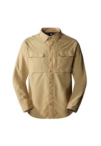 Camicia beige a maniche lunghe realizzata in tessuto leggero. Presenta due tasche sul petto, chiusura frontale con bottoni e un colletto classico con dettagli cuciti.