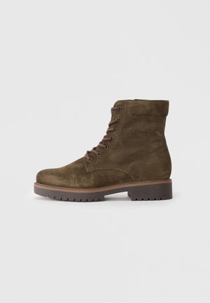 Brown suede ankle boot with round toe, lace-up front, padded collar, and rubber sole featuring a textured pattern for grip.