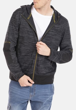 Haut à capuche zippé noir et gris mélangé avec une finition texturée, manches noires contrastantes et coutures accentuées en jaune. Design à capuche pour plus de chaleur.