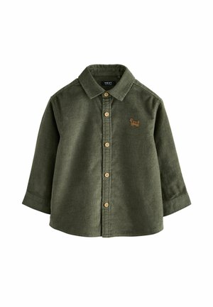 Chemise en velours côtelé kaki à manches longues avec boutons en bois et petit chien marron brodé sur la poitrine, le col et le devant boutonné.
