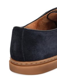 Granatowe zamszowe buty o gładkiej fakturze, zaokrąglonym kształcie i brązowej gumowej podeszwie. Szew wzdłuż podeszwy dodaje subtelnego kontrastu.