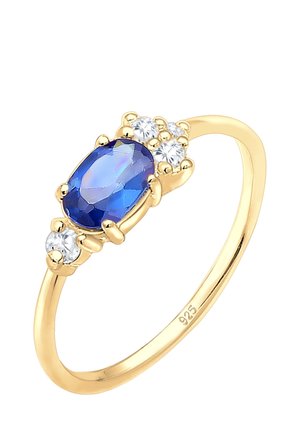 Gold ring with an oval blue gemstone centerpiece flanked by five small round white stones on a simple band marked 925.