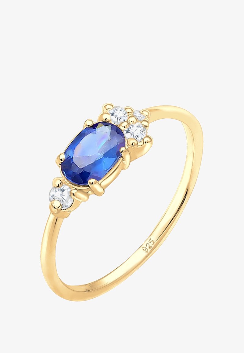 Bague en or avec une pierre centrale ovale bleue encadrée de cinq petites pierres rondes blanches sur une monture simple marquée 925.