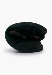 Zapatilla de fieltro verde con interior suave y suela de goma negra texturizada, con forma redondeada y costuras visibles.