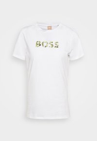 T-shirt di cotone bianco con stampa "BOSS" in verde foglia, colletto rotondo, maniche corte e vestibilità rilassata. Design minimalista, senza pattern.