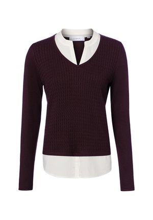 Haut en maille à manches longues violet foncé avec motif texturé, superposé sur un col et un bas de chemise blancs visibles au niveau de l'encolure et du bas.