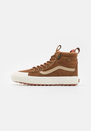 Brauner High-Top-Sneaker aus Wildleder mit weißer Sohle, beigem Seitenstreifen, Metallösen und Zuglaschen an Zunge und Ferse.