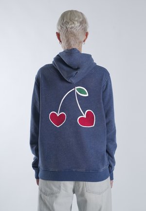 Navy blauwe hoodie van katoen met een witte geborduurde afbeelding met rode harten en een groene blad op de achterkant. Eenvoudig, casual ontwerp.