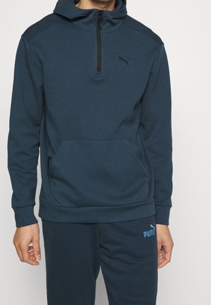 Felpa con zip blu scuro, tasca a marsupio, polsini a coste e logo discreto sul petto. Tessuto morbido con una texture liscia e design minimal.