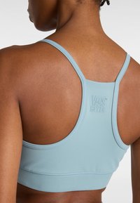 Lichtblauwe sportbeha met een gladde textuur, dunne bandjes en een racerback ontwerp. Bevat een op de rug geperst Vans-logo.