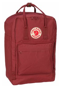 Mochila Fjällräven Kånken roja, hecha de un tejido resistente, que presenta un bolsillo frontal, un asa superior y un parche circular con el logo en el frontal.