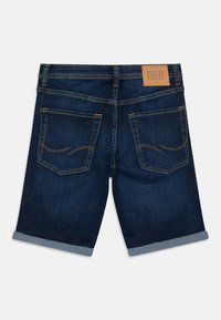 Shorts in denim blu scuro con orlo arrotolato, dotati di due tasche posteriori e dettagli cuciti; etichetta in pelle con marchio sulla vita.
