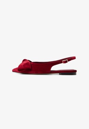 Scarpe slingback piatte in velluto rosso con dettaglio a fiocco sulla punta. Forma appuntita, lati aperti e una tracolla sottile con hardware dorato.
