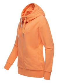 Šviesiai oranžinė zip-up džemperis su aukštu kaklu, subalansuotomis rankogaliais ir lygia tekstūra. Ant krūtinės yra mažas logotipas.