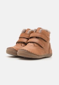 Bottes en cuir marron avec deux sangles Velcro réglables, doublure en fourrure grise douce et semelle en caoutchouc avec motifs de grip texturés.