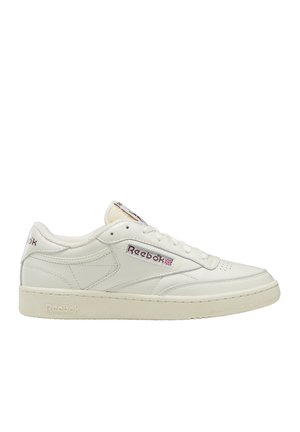Zapatilla blanca de cuero con un diseño de corte bajo, que presenta costuras sutiles, un forro interior suave y una suela de goma. Logo de Reebok en el lateral.