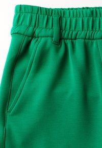 Pantalon de jogging vert en tissu doux et extensible, avec une taille élastique, une boucle de ceinture et des poches latérales. Texture lisse, sans motifs.