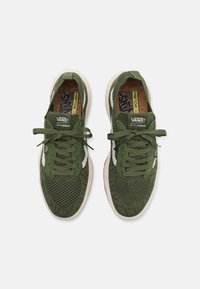 Groene mesh sneakers met witte accenten, voorzien van ronde veters, een gestructureerde neuskap en een gewatteerde kraag voor comfort. VANS-logo zichtbaar.