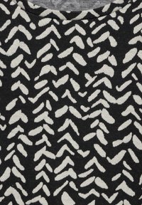Schwarz-weißer stoff mit einem Muster aus abstrakten Formen und einer weichen Textur. Das Design umfasst unregelmäßige diagonale Linien und unterschiedliche Längen.