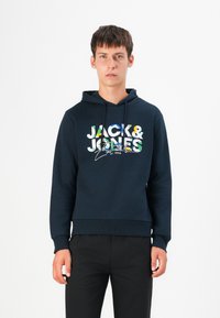 Marineblaue Kapuzenjacke mit Kordelzug, versehen mit einem mehrfarbigen Grafikdruck von "JACK & JONES" auf der Vorderseite, gerippten Bündchen und Saum.