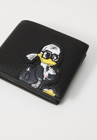 Carteira de couro texturizado preto com um gráfico em relevo de um pato em fraque e óculos de sol, com detalhes em amarelo, branco e preto.