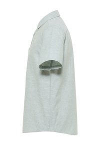 Jasnozielona koszula z krótkim rękawem z zapięciem na guziki, wykonana z teksturowanej tkaniny, o prostym kroju i nieco dłuższym tylnym panelu.