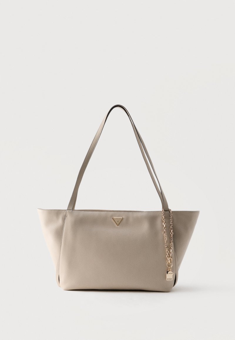 Sac bandoulière en cuir beige avec longues lanières, logo triangulaire et chaîne dorée avec petit pendentif cadenas suspendu sur le côté.