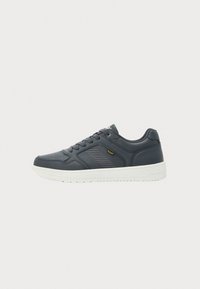 Mørkegråt lave sneakers med hvit såle, snøring, strukturert sidepanel og gult "Lee"-merke på siden.