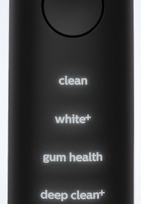 Manico di spazzolino elettrico nero con quattro impostazioni illuminate: "pulizia", "bianco +", "salute gengivale" e "pulizia profonda +" visualizzate verticalmente.