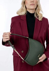 Grüne Ledertasche mit einer geschwungenen Form und strukturierten Oberflächen. Verfügt über einen kurzen Tragegurt und goldfarbene Hardware-Details.