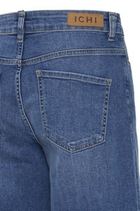 Πίσω πλευρά μπλε τζιν από denim που δείχνει μια μονή τσέπη με σήμα και μια καφέ δερμάτινη ετικέτα με την επωνυμία «ICHI» στη ζώνη μέσης.