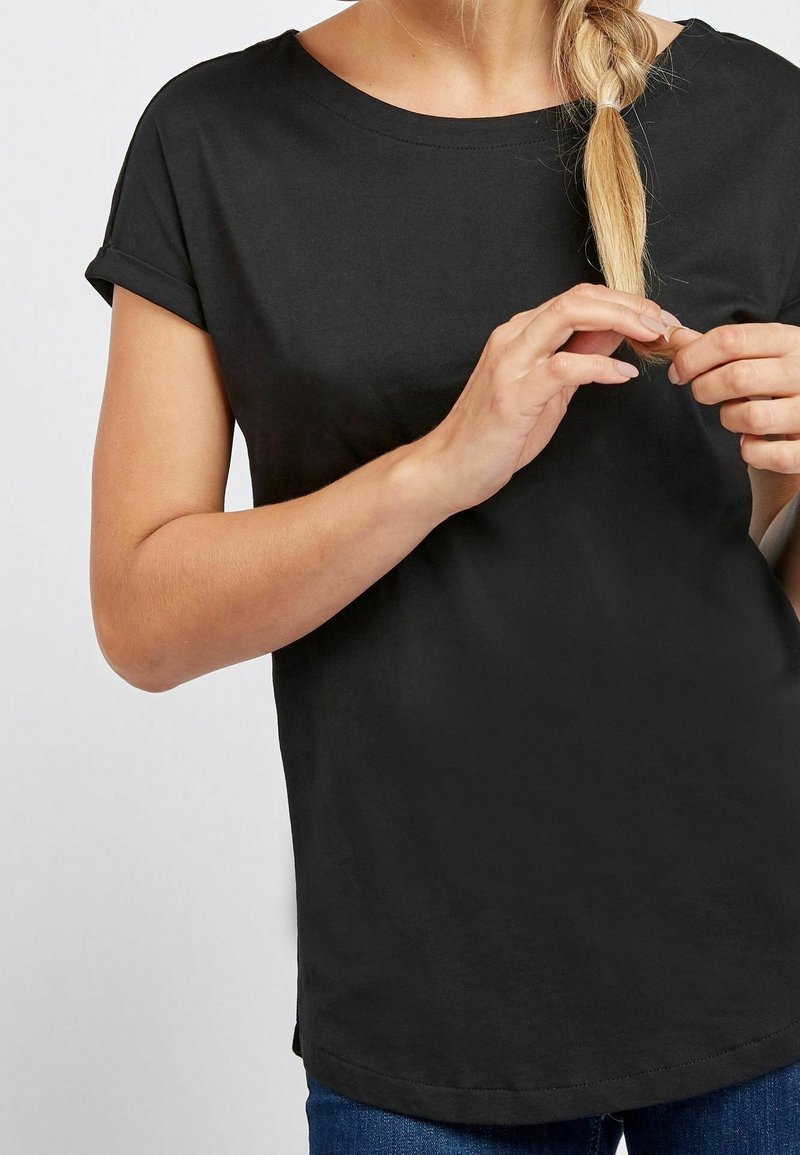 T-shirt noir à manches courtes avec un col rond, fabriqué dans un tissu doux ; possède des revers aux manches et une coupe décontractée.