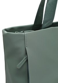 Borsa a tracolla verde realizzata in tessuto testurizzato, dotata di una tasca con zip, manici robusti e cuciture rinforzate lungo i bordi.