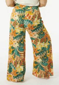 Pantalons larges à motifs floraux présentant un motif vibrant de fleurs orange, vertes et jaunes avec des feuilles, un tissu texturé et une taille élastique.