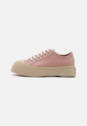 Pink leather sneakers with a rounded toe, textured, thick beige sole, and white laces. Features metallic eyelets and a logo detail at the heel.