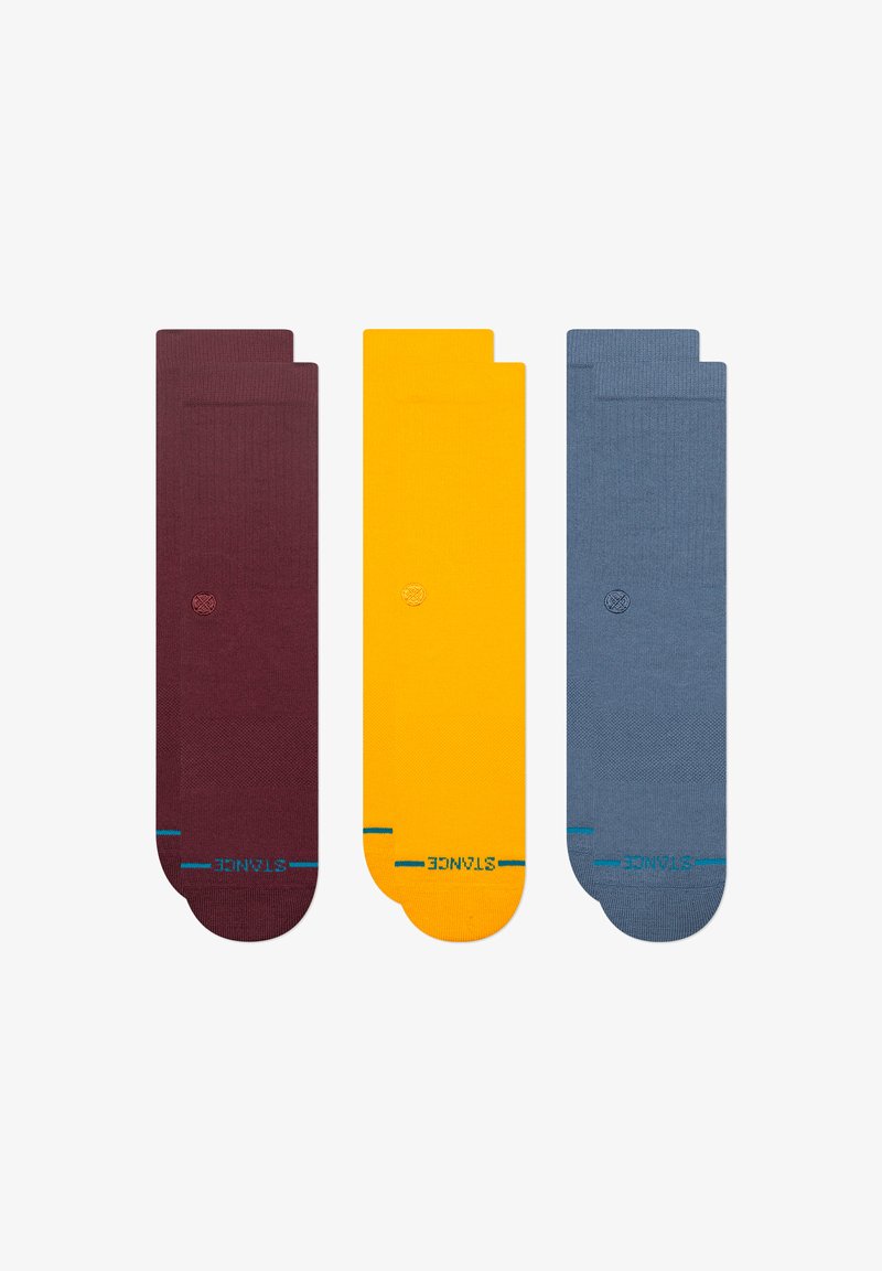 Conjunto de três meias: borgonha, amarelo e azul. Feitas de tecido malhado com uma textura suave e acentos em turquesa contrastantes perto dos dedos.
