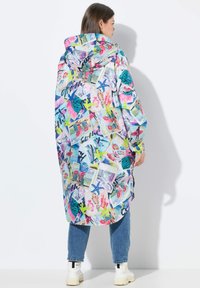 Hooded regenjas in een meerkleurige print met maritieme motieven, vormen en levendige kleuren. Losse pasvorm, met zijsplitten en een lichte textuur.