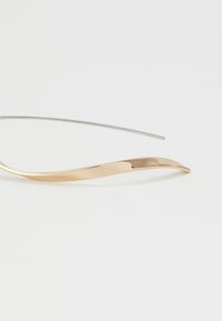 Gold-tone metal eyeglass frame with a sleek, curved design. Thin silver metal arm extends from the frame, creating a minimalist look.