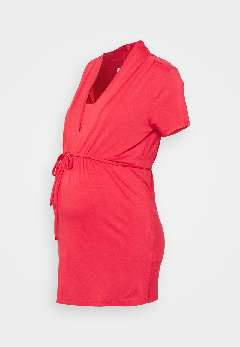 Vestido de maternidade vermelho com mangas curtas, decote em V e cintura ajustável com laço, concebido para acomodar uma barriga em crescimento.