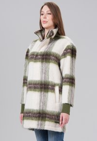 Wool blend coat featuring a white base with green and brown plaid patterns. High collar, button details, and two side pockets.