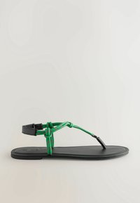 Zwarte platte sandaal met een ontwerp van groen en roze koord. Het koord wikkelt zich om de enkel en vormt een teenlus. Soepele textuur op de zool.