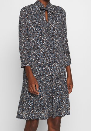 Black floral dress with blue and white flowers, three-quarter sleeves, and a small keyhole neckline with a tied bow.